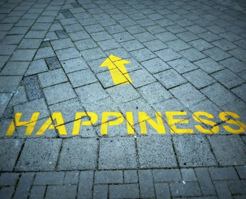 a brick sidewalk with a yellow arrow painted on it