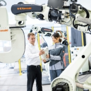 a man and a woman standing in front of a robot