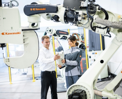 a man and a woman standing in front of a robot