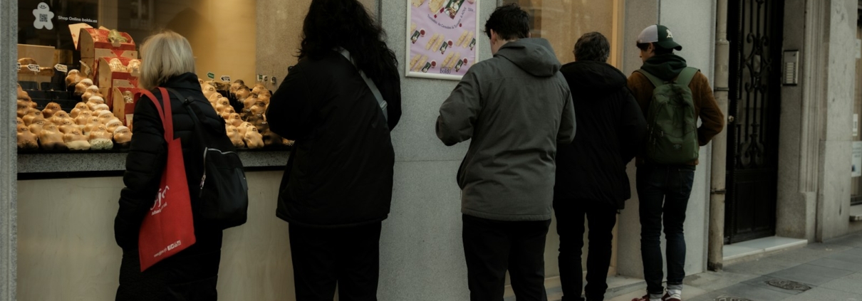 A group of people standing outside of a bakery