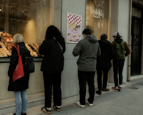 A group of people standing outside of a bakery