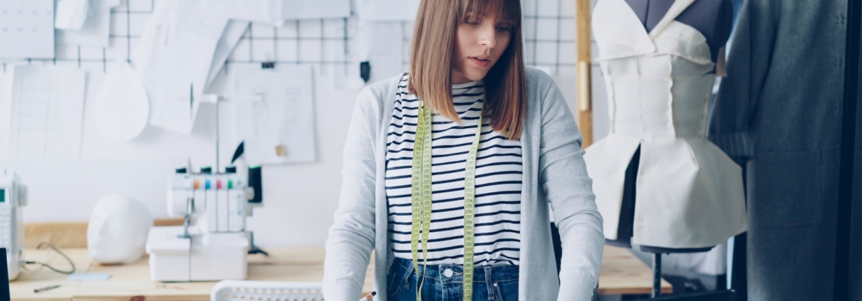 A fashion designer works at a laptop.