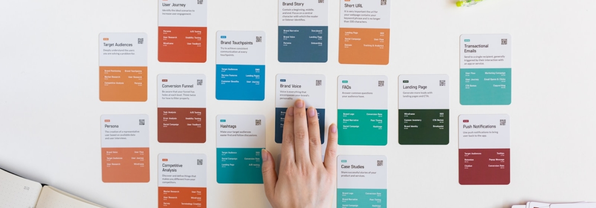 a person's hand on a piece of paper next to a bunch of colored