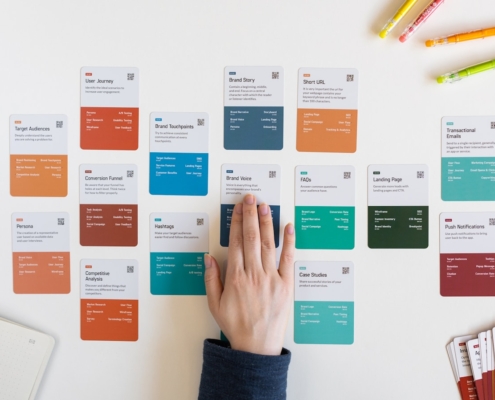 a person's hand on a piece of paper next to a bunch of colored