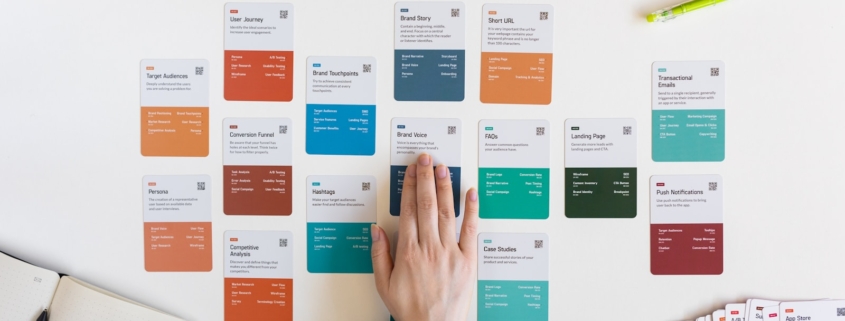 a person's hand on a piece of paper next to a bunch of colored