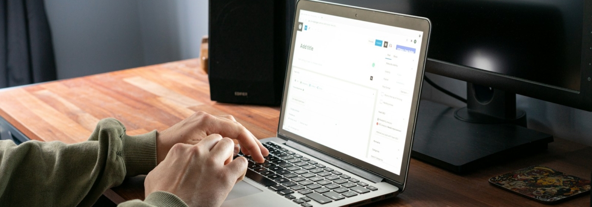 person in gray jacket using macbook pro