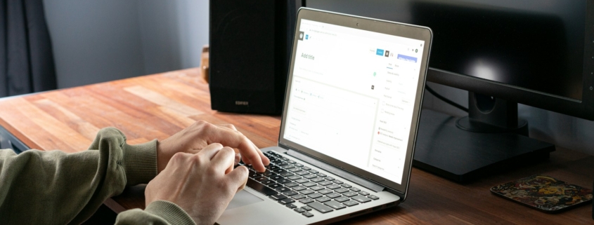 person in gray jacket using macbook pro